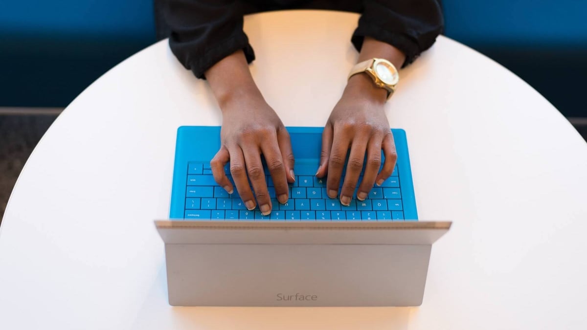 Image of person's hand of laptop's keyboard