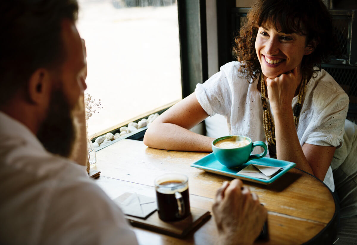 Man and woman smiling over coffee