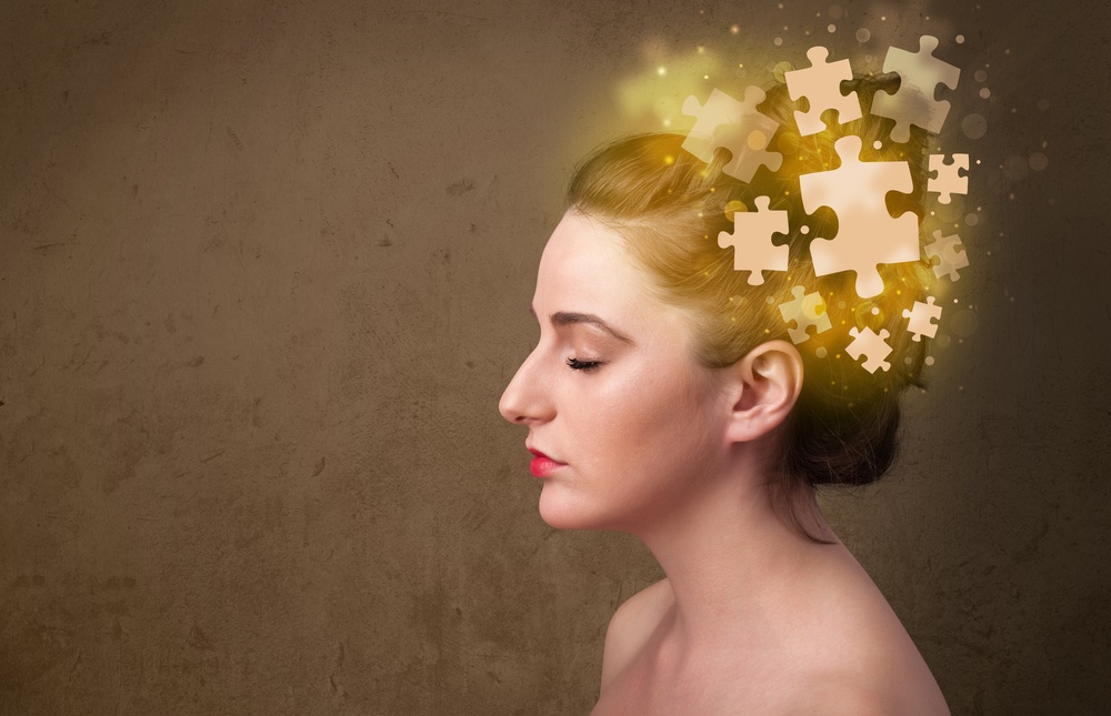 Young woman thinking with glowing puzzle pieces on mind